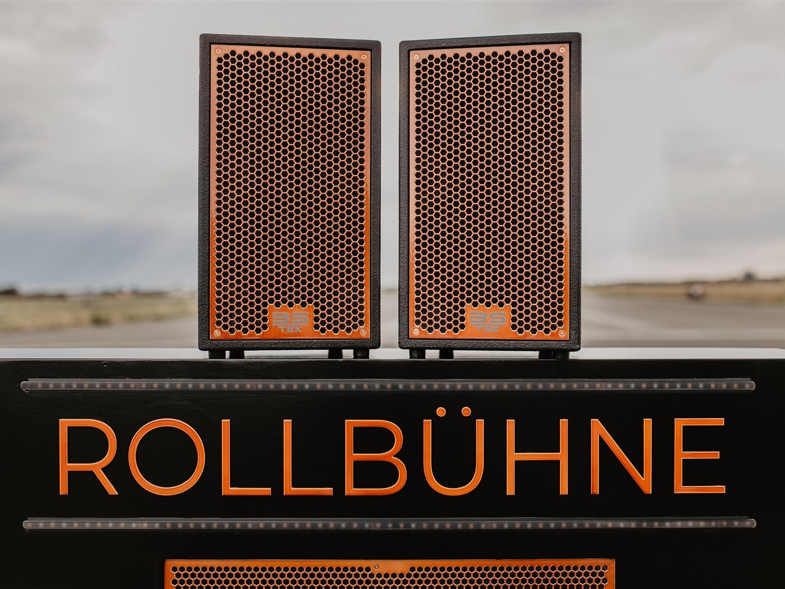 Die Rollbühne: Lautsprecher auf dem schwarzen Lastenrad-Aufbau mit orangefarbenem Schriftzug