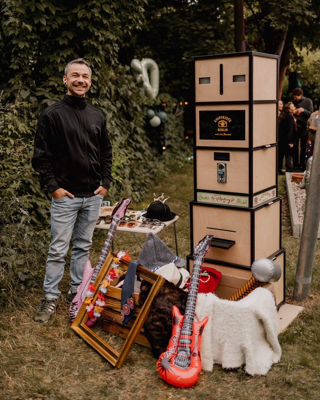 Chris neben der Knipskiste bei einer Gartenfeier mit Props-Tisch